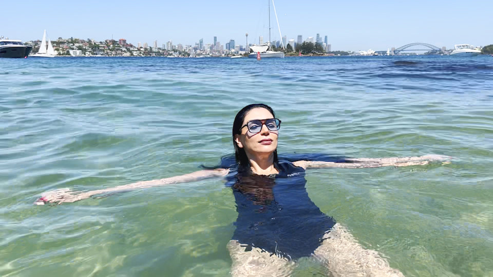 Load video: Woman wearing FloatEzy swimsuit swimming in Sydney harbour to demonstrate the superior buoyancy.
